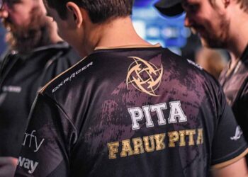 a man wearing a black shirt with gold text